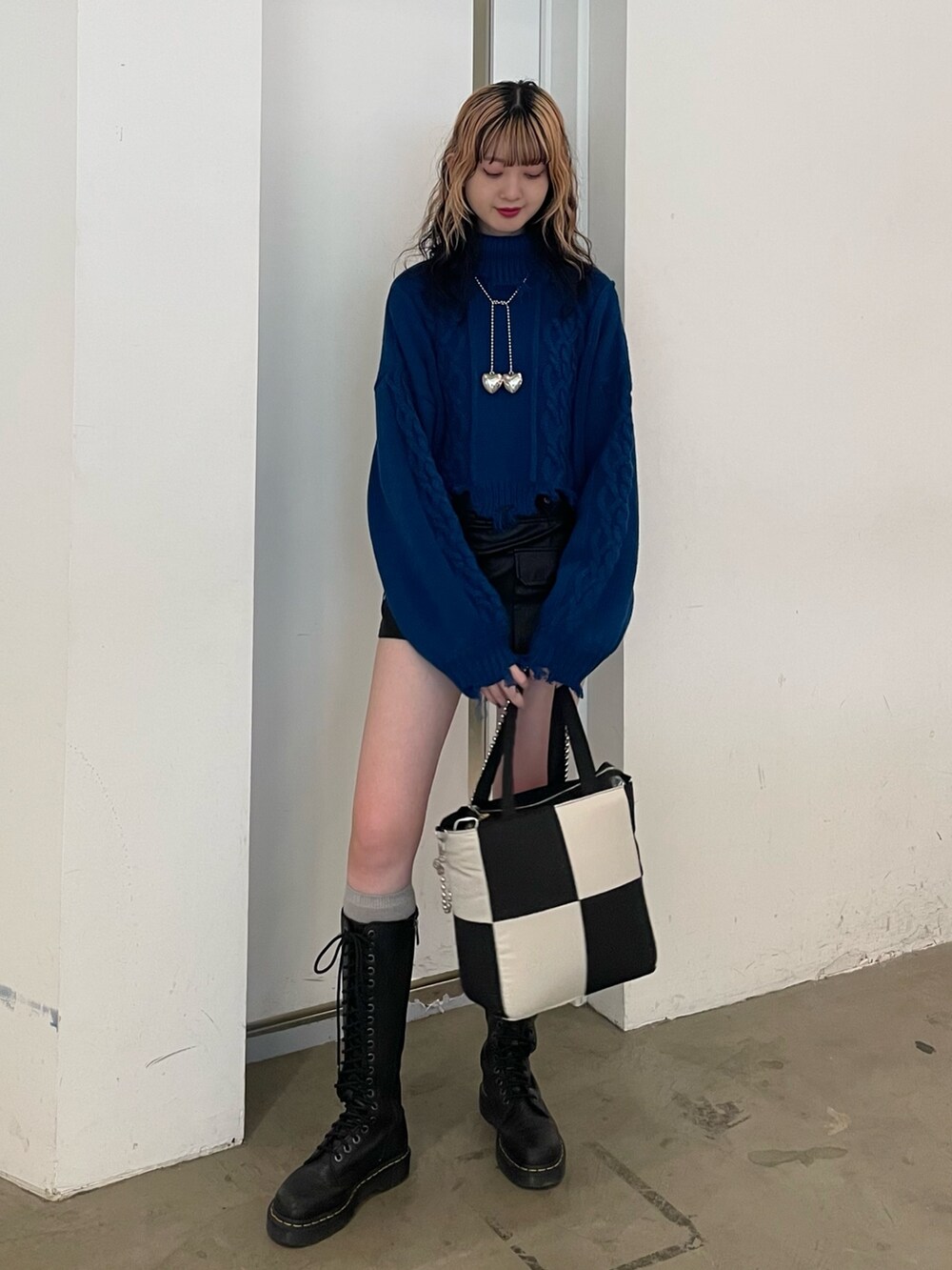 ブラック系のその他パンツ、ブルー系のニット/セーター、ブラック系のブーツを着用したレディースの冬コーディネートの2枚目の写真