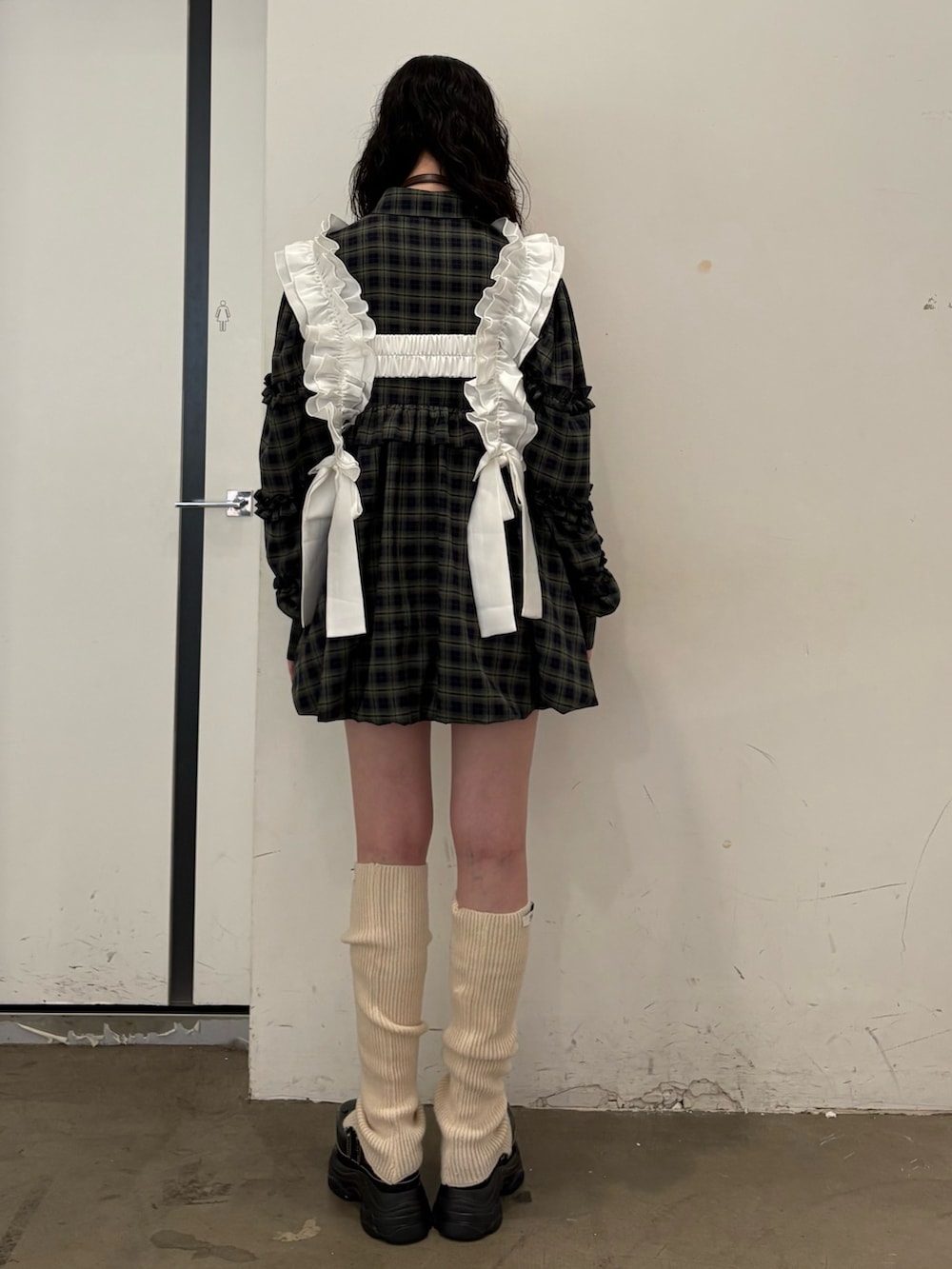 グリーン系のワンピース、ブラック系のスニーカー、ホワイト系のベルトを着用したレディースの夏コーディネートの3枚目の写真