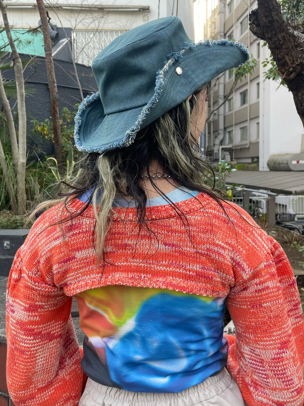 ブラック系のTシャツ/カットソー、オレンジ系のニット/セーター、ホワイト系のその他パンツを着用したレディースの冬コーディネートの9枚目の写真