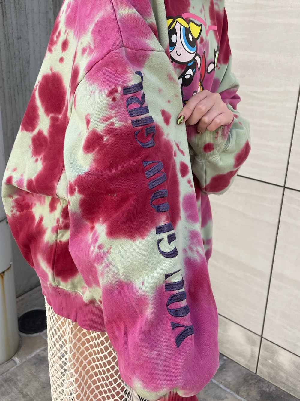 グリーン系のスウェット、ホワイト系のワンピース、ブラック系のブーツを着用したレディースの冬コーディネートの7枚目の写真