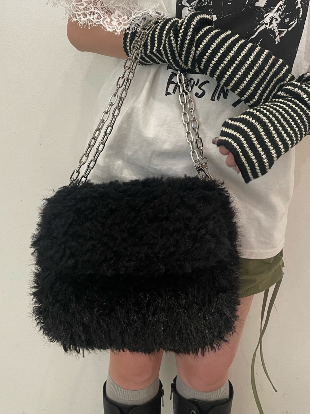 ホワイト系のTシャツ/カットソー、ブラック系のハンドバッグ、ブラック系のブーツを着用したレディースの夏コーディネートの7枚目の写真