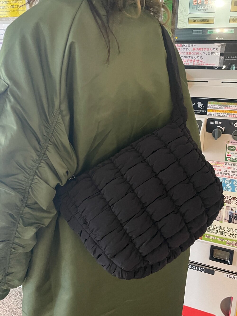 グリーン系のMA-1、ブラック系のブーツ、ブラック系のハンドバッグを着用したレディースの秋コーディネートの7枚目の写真