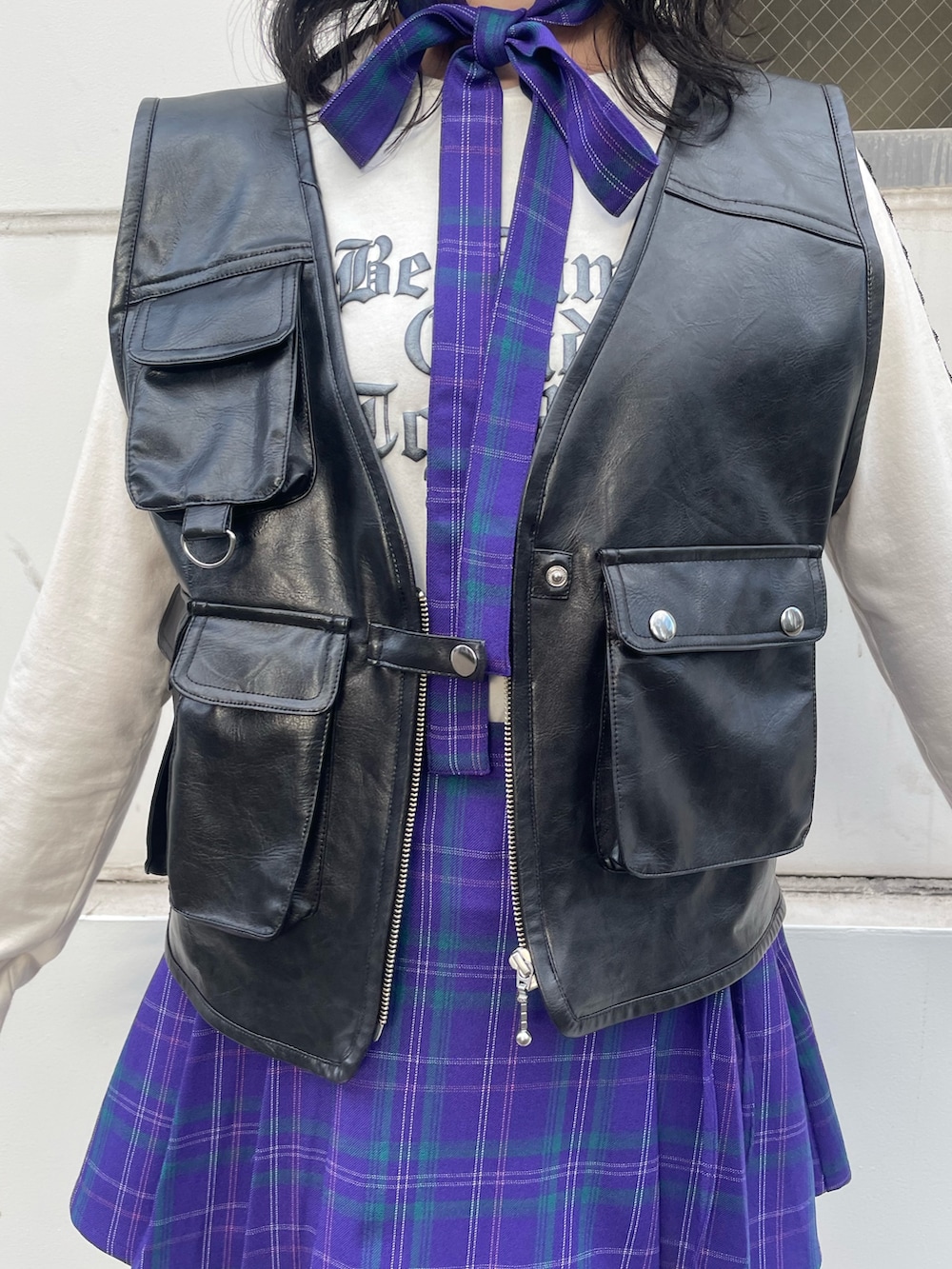 ブラック系のスニーカー、ブラック系のベスト、ホワイト系のTシャツ/カットソーを着用したレディースの冬コーディネートの6枚目の写真