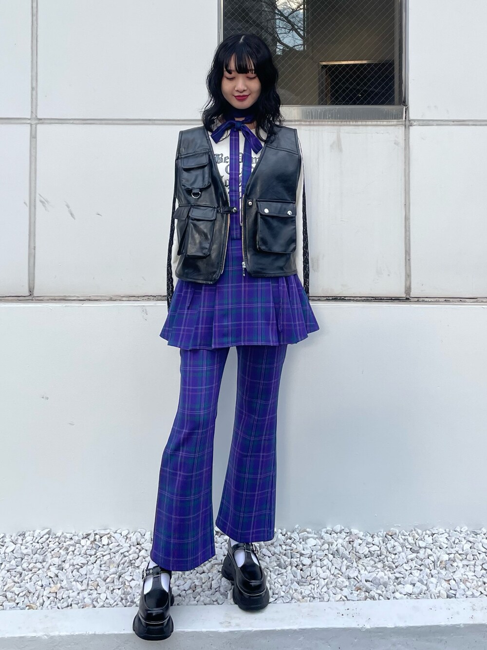 ブラック系のスニーカー、ブラック系のベスト、ホワイト系のTシャツ/カットソーを着用したレディースの冬コーディネートの2枚目の写真