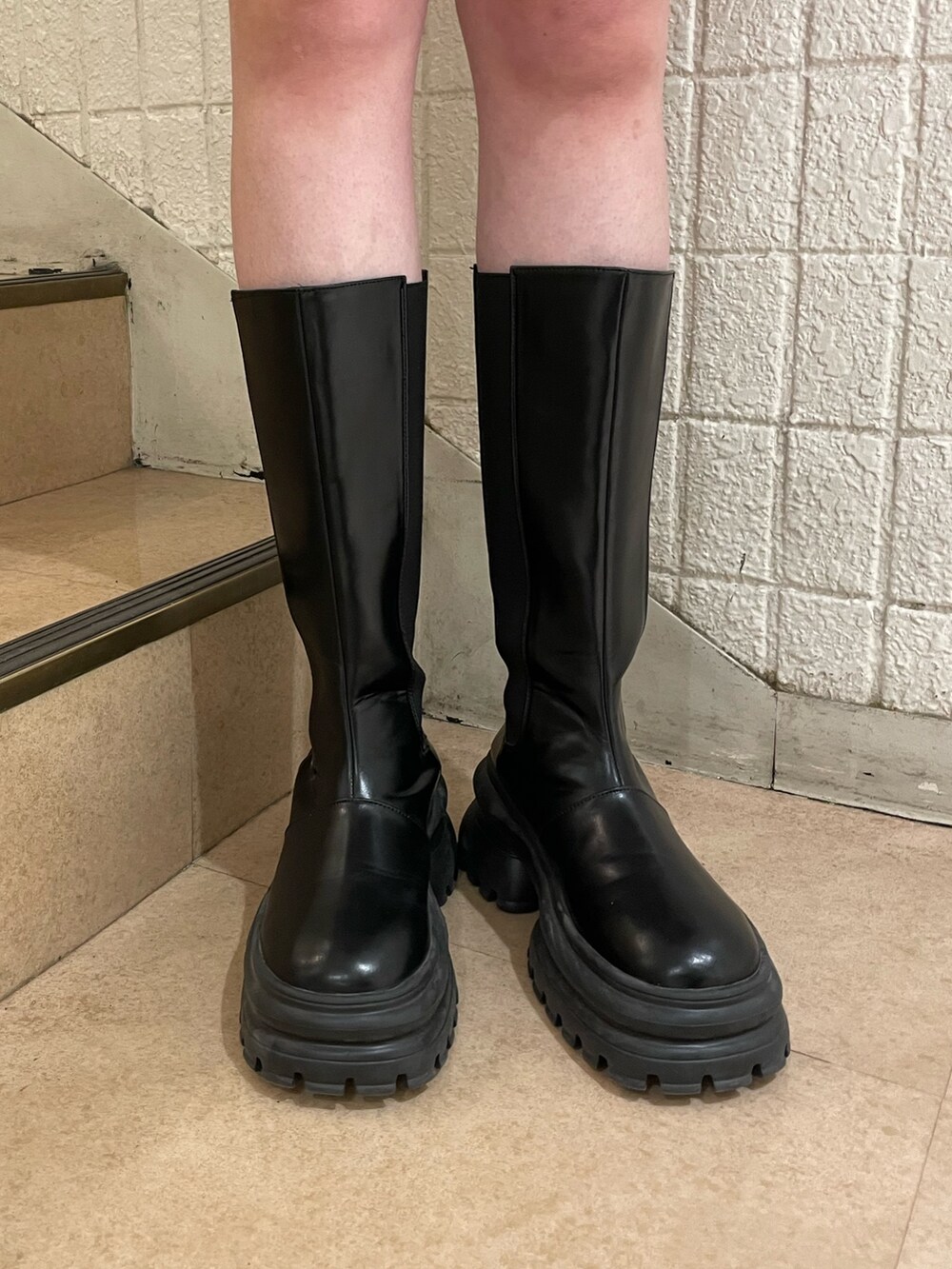 ブラック系のスウェット、ブルー系のデニムパンツ、ブラック系のブーツを着用したレディースの冬コーディネートの9枚目の写真