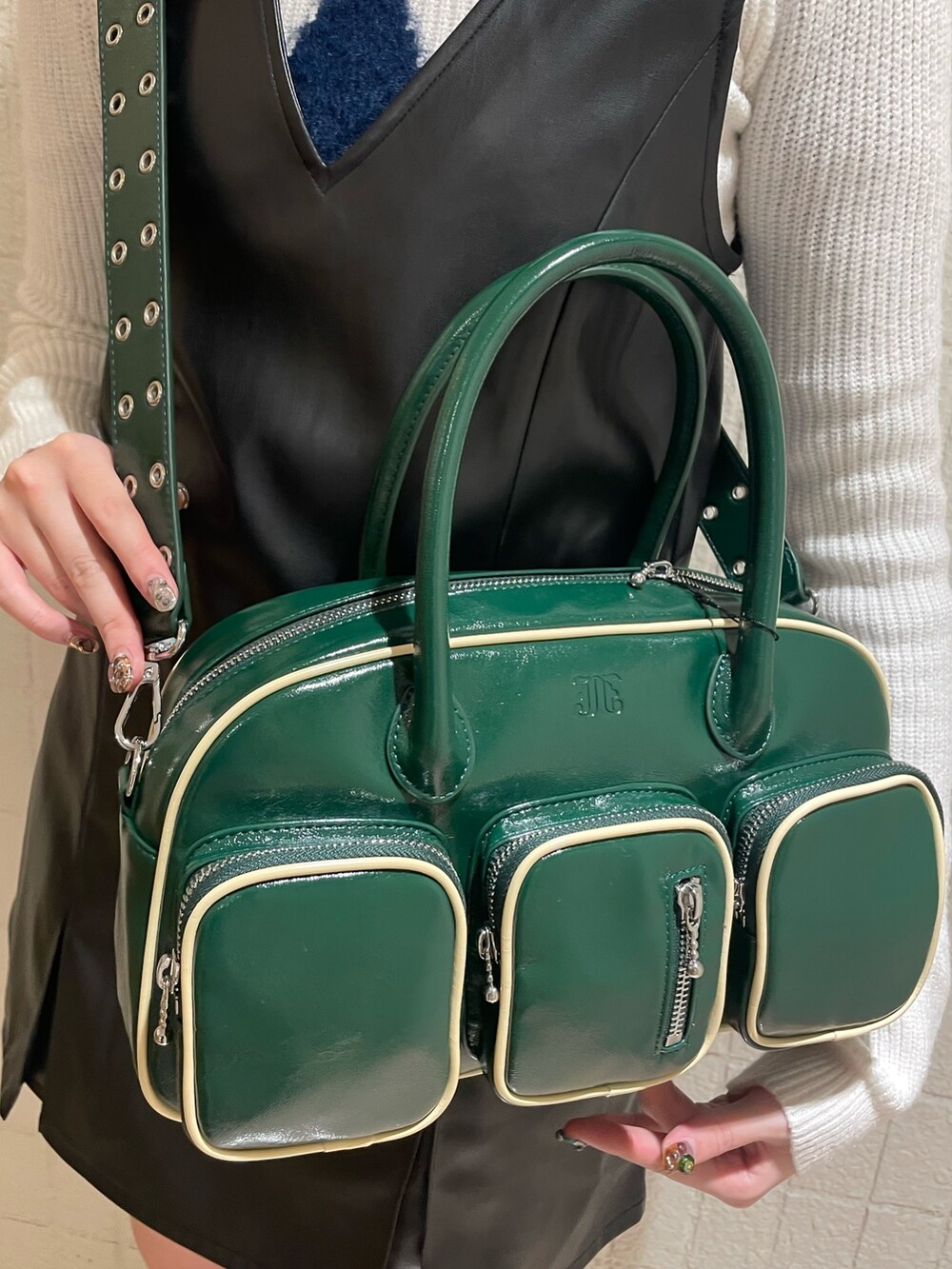 パープル系のブルゾン、ホワイト系のニット/セーター、ブラック系のジャンパースカートを着用したレディースの秋コーディネートの9枚目の写真