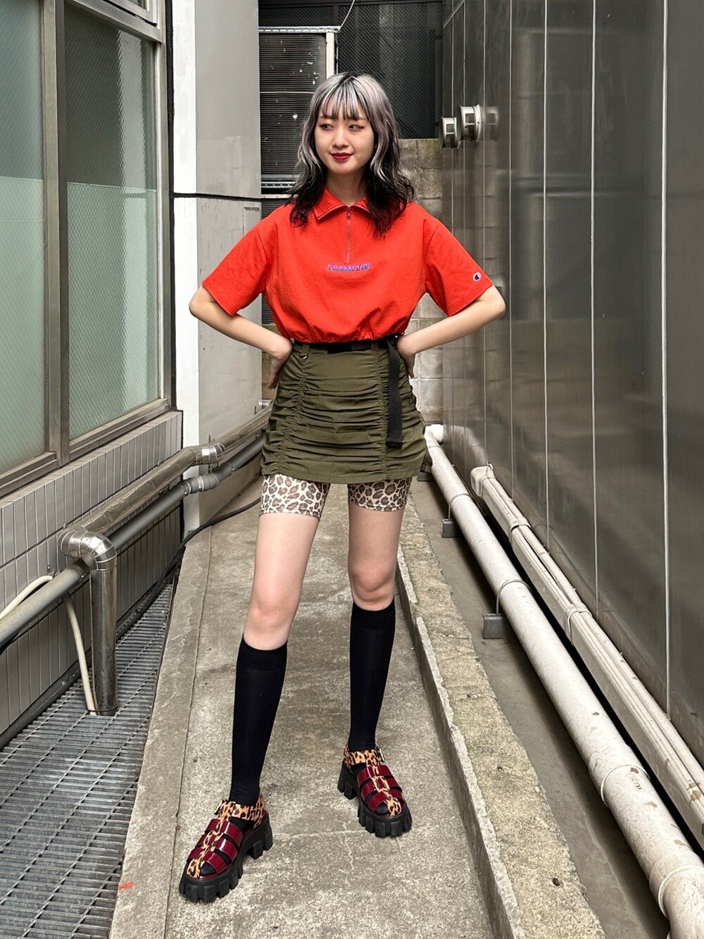 レッド系のTシャツ/カットソー、グリーン系のスカート、ベージュ系のその他パンツを着用したレディースの春コーディネートの2枚目の写真