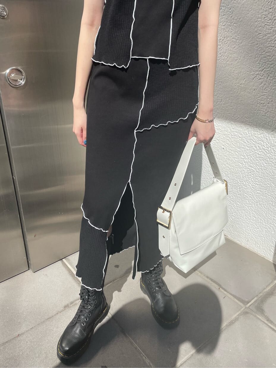 ブラック系のスカート、ブラック系のTシャツ/カットソー、シルバー系のネックレスを着用したレディースの春コーディネートの6枚目の写真