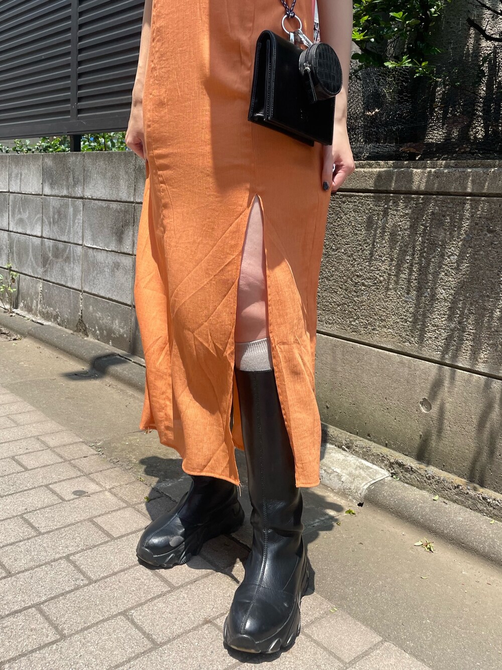 ブラック系のTシャツ/カットソー、オレンジ系のワンピース、ブラック系のショルダーバッグを着用したレディースの夏コーディネートの6枚目の写真