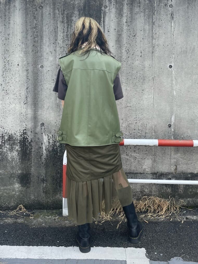 ブラック系のブーツ、ベージュ系のスカート、ホワイト系のベストを着用したレディースの秋コーディネートの3枚目の写真