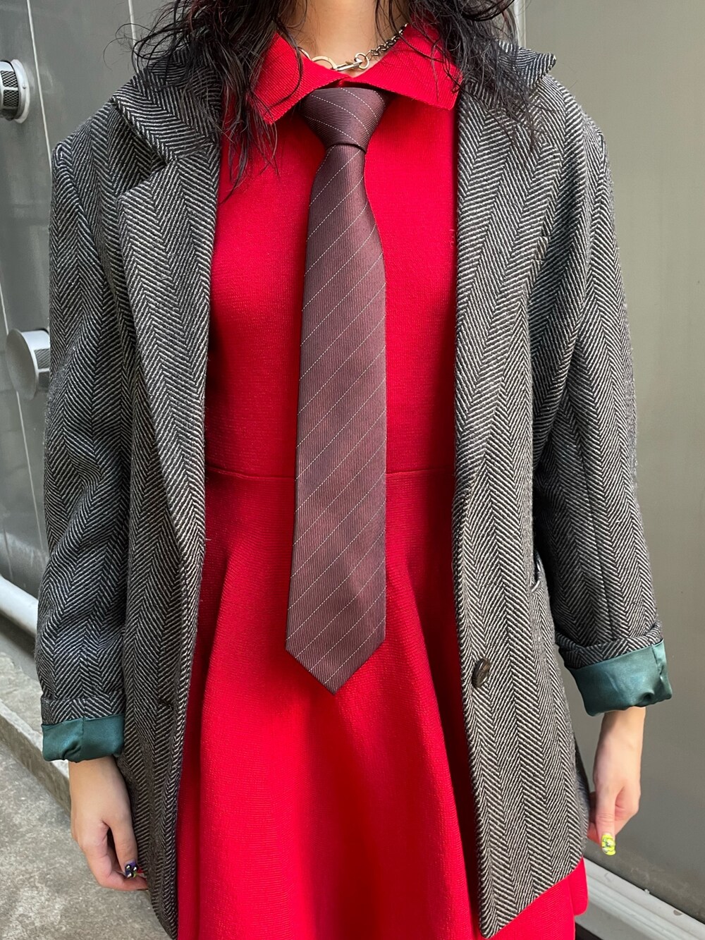 グレー系のテーラードジャケット、レッド系のネクタイ、レッド系のワンピースを着用したレディースの夏コーディネートの6枚目の写真