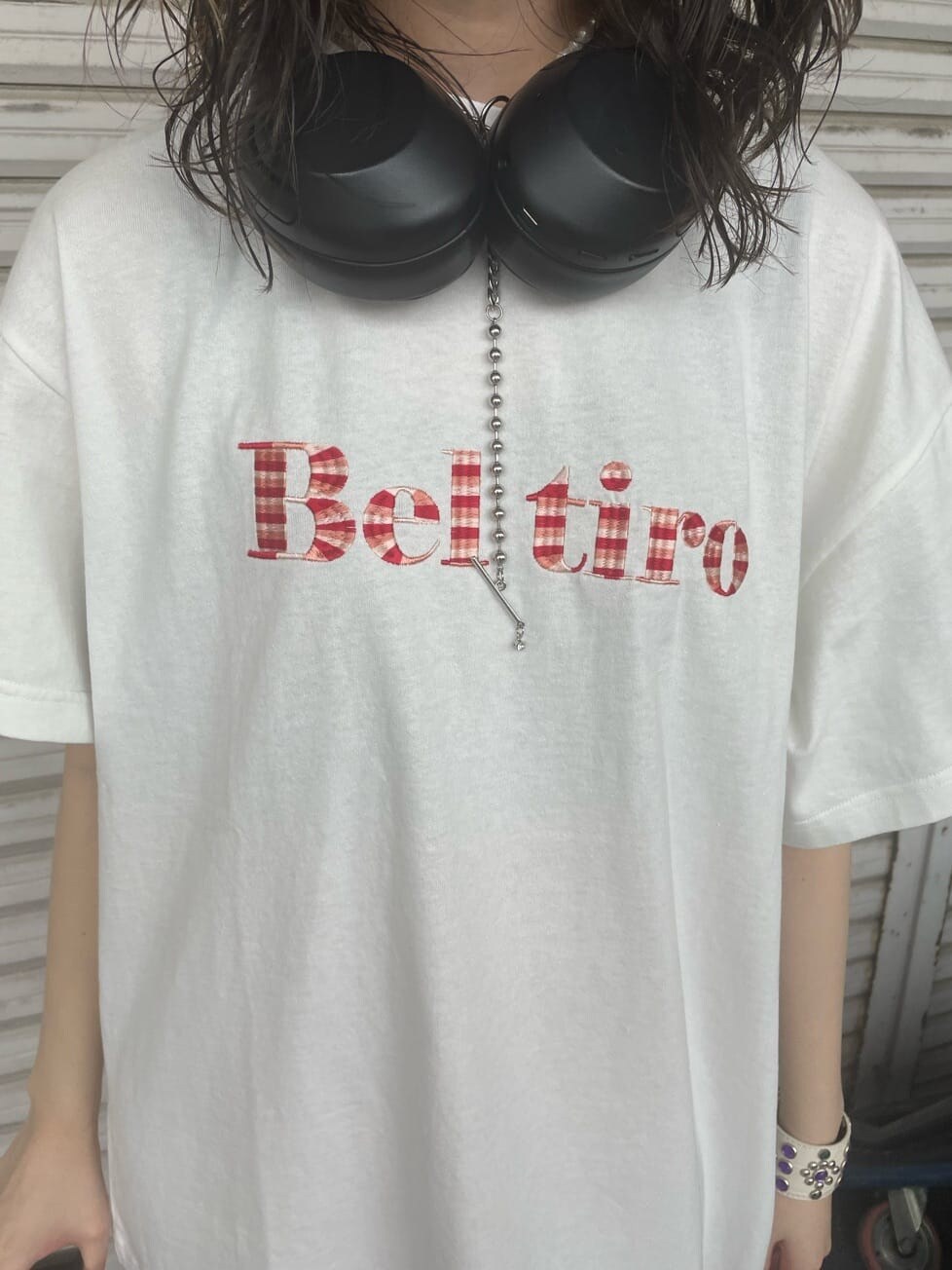 ブラック系のブーツ、ホワイト系のTシャツ/カットソー、ブラック系のハンドバッグを着用したレディースの春コーディネートの6枚目の写真