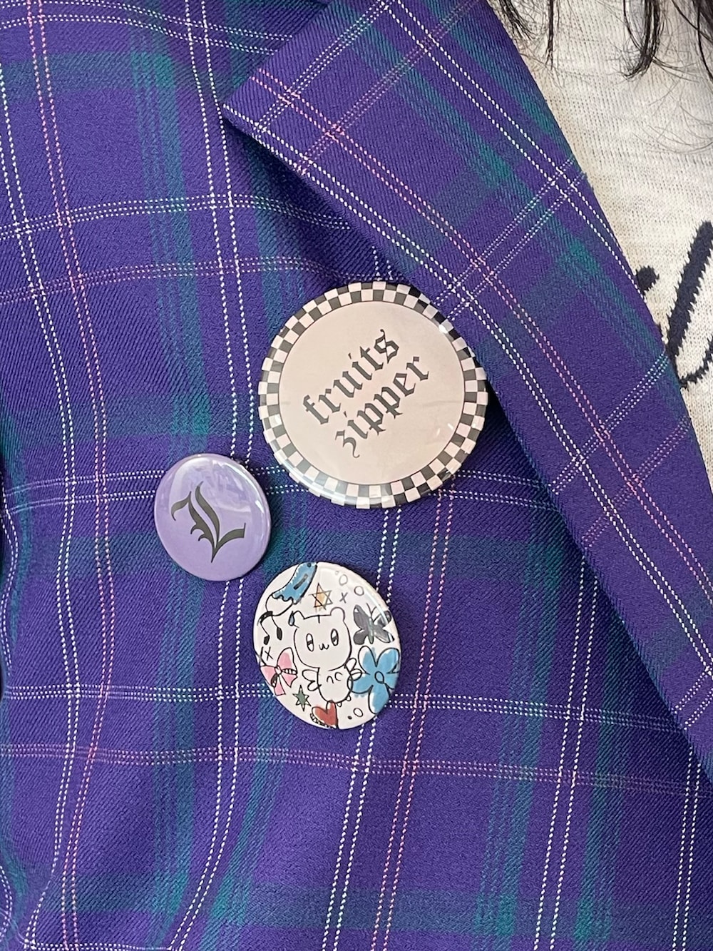 ホワイト系のニット/セーター、パープル系のテーラードジャケット、パープル系のスカートを着用したレディースの冬コーディネートの6枚目の写真