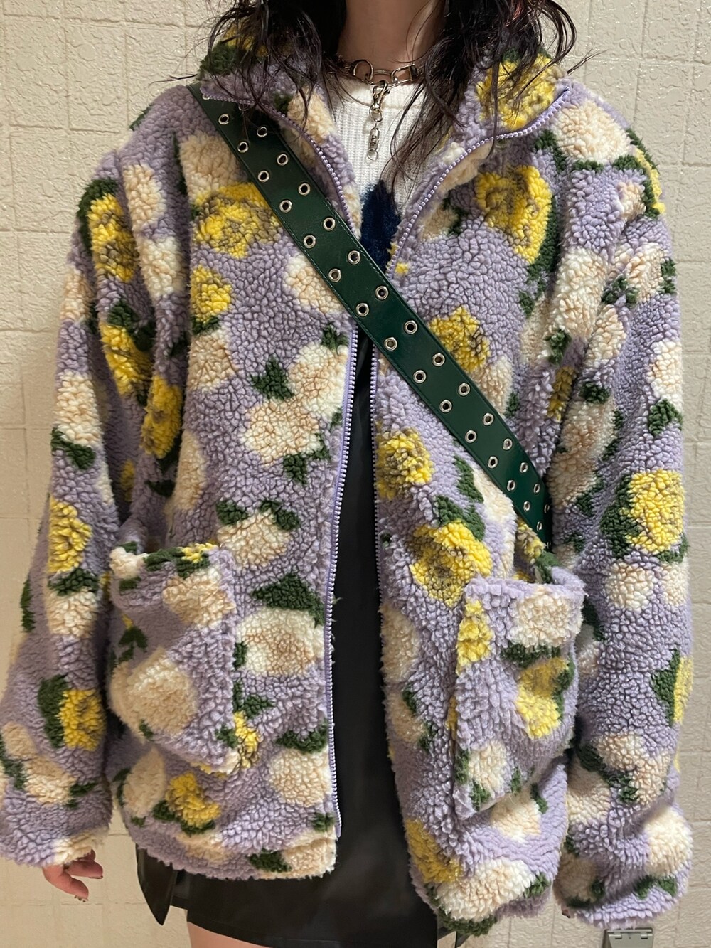 パープル系のブルゾン、ホワイト系のニット/セーター、ブラック系のジャンパースカートを着用したレディースの秋コーディネートの7枚目の写真