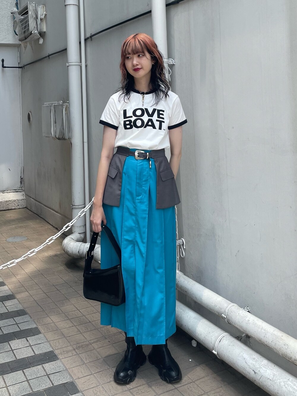 ホワイト系のTシャツ/カットソー、ブルー系のスカート、ブラック系のハンドバッグを着用したレディースの春コーディネートの2枚目の写真