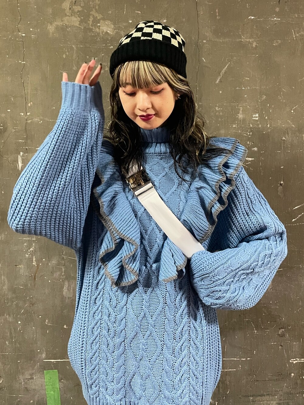 ブラック系のブーツ、ホワイト系のハンドバッグ、ブルー系のニット/セーターを着用したレディースの冬コーディネートの5枚目の写真