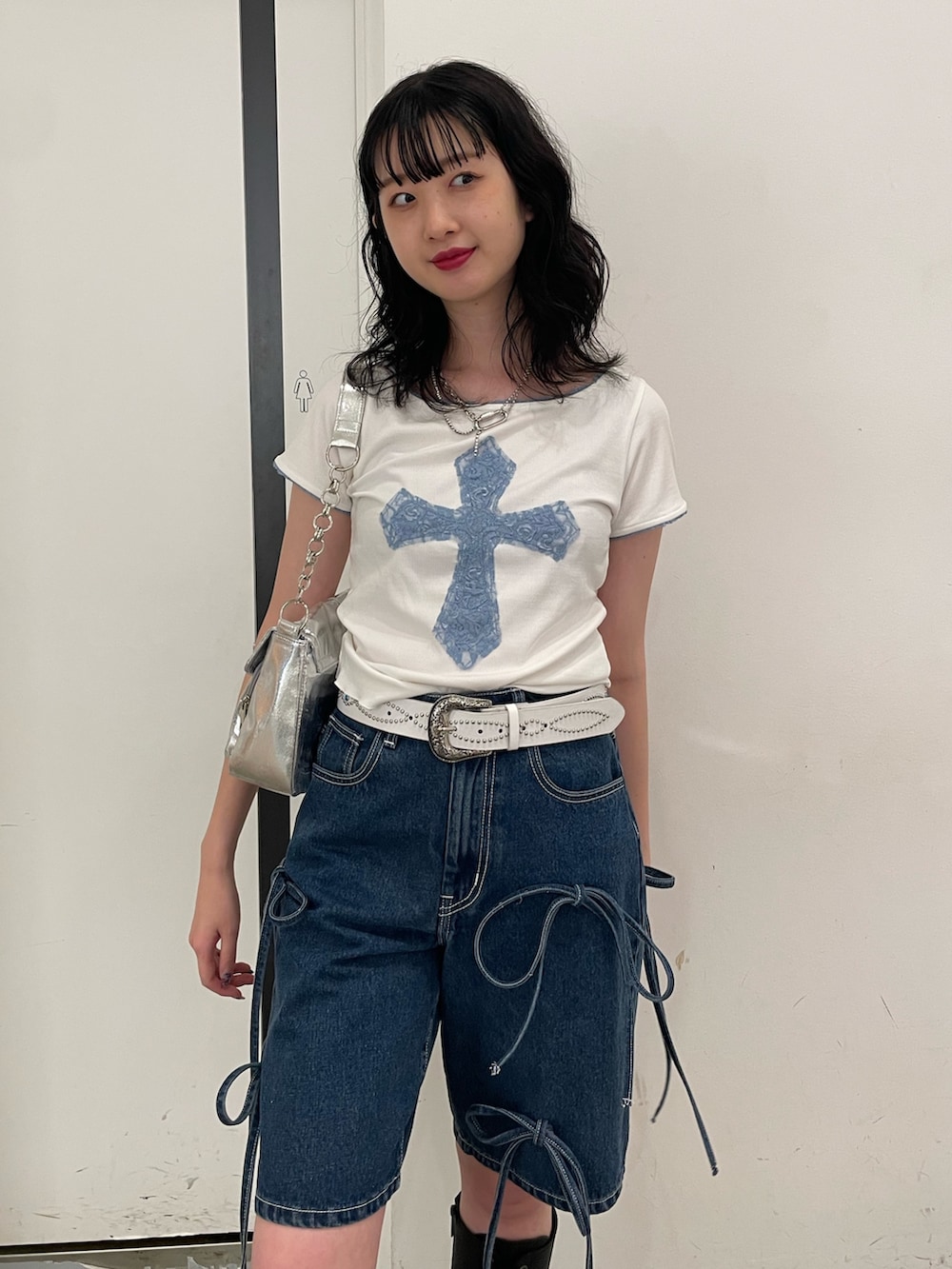 ホワイト系のTシャツ/カットソー、シルバー系のハンドバッグ、ブルー系のデニムパンツを着用したレディースの春コーディネートの3枚目の写真