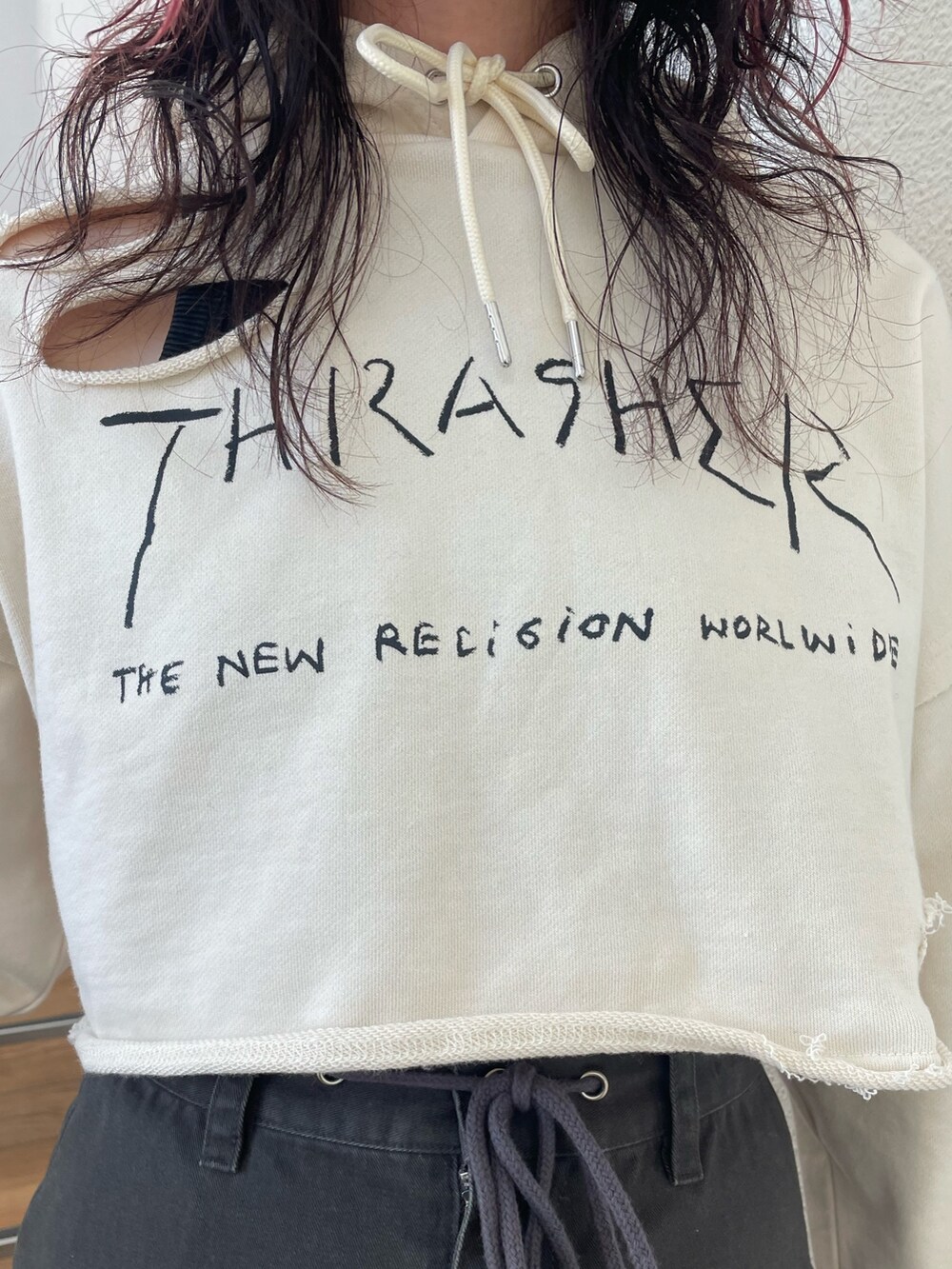 ホワイト系のパーカー、レッド系のブーツ、ブラック系のスカートを着用したレディースの春コーディネートの4枚目の写真