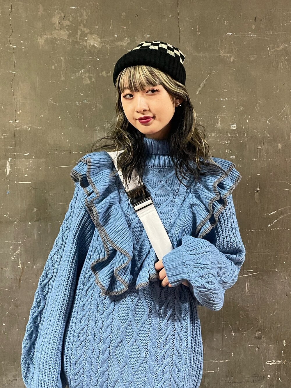 ブラック系のブーツ、ホワイト系のハンドバッグ、ブルー系のニット/セーターを着用したレディースの冬コーディネートの4枚目の写真