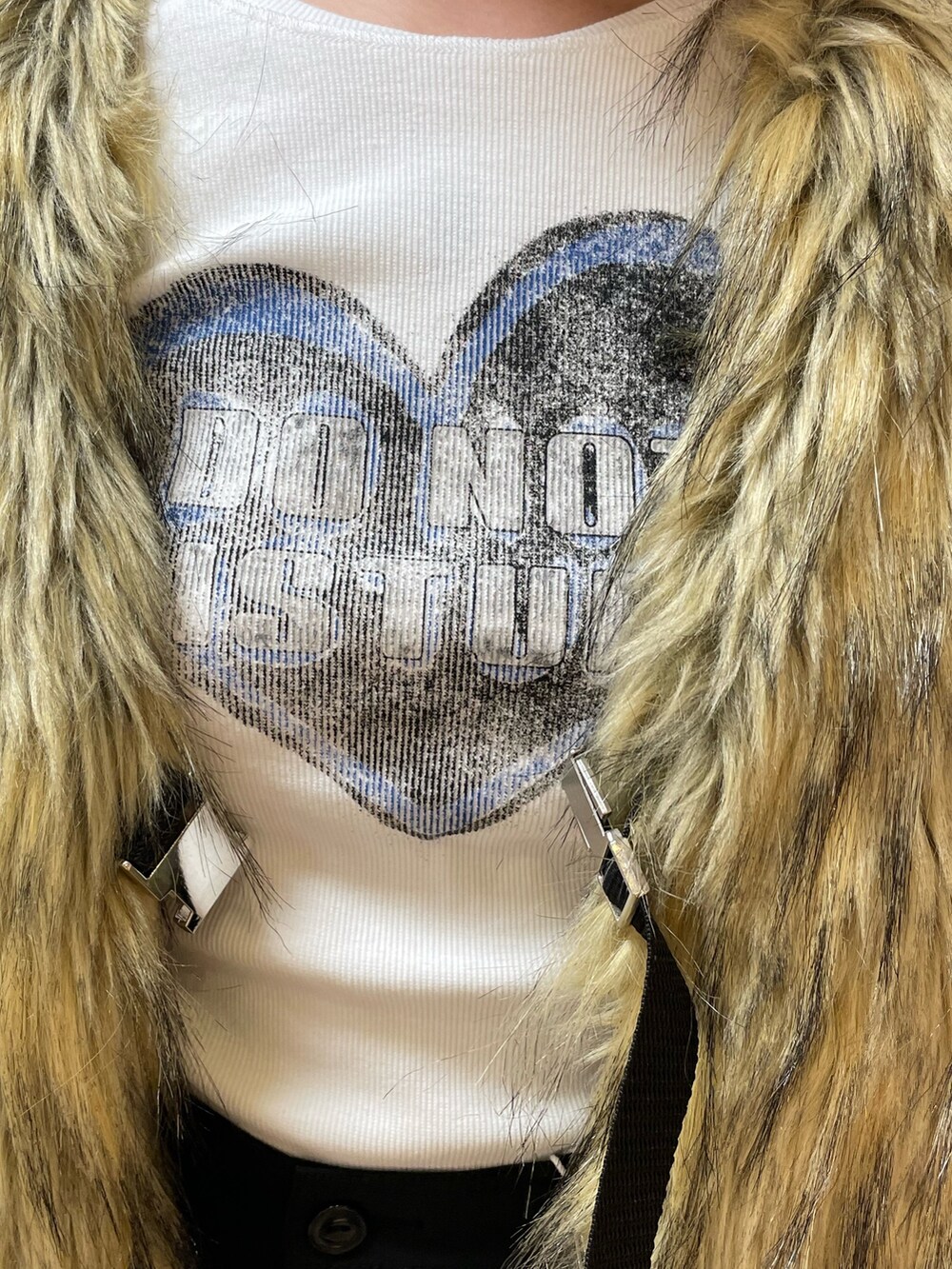 ベージュ系のベスト、ホワイト系のTシャツ/カットソー、ブラック系のスカートを着用したレディースの秋コーディネートの5枚目の写真