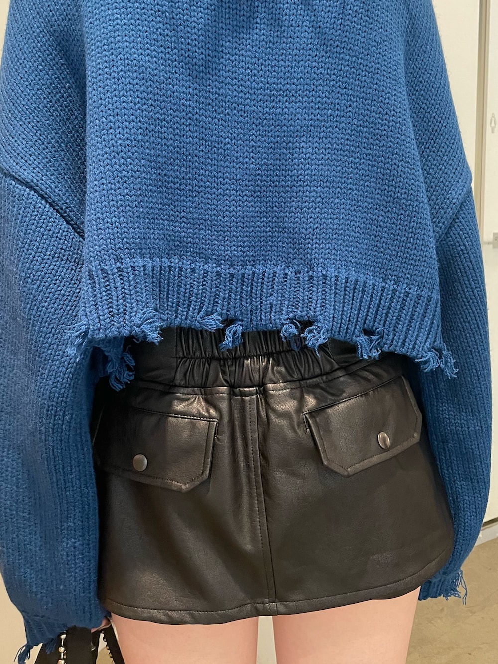 ブラック系のその他パンツ、ブルー系のニット/セーター、ブラック系のブーツを着用したレディースの冬コーディネートの7枚目の写真