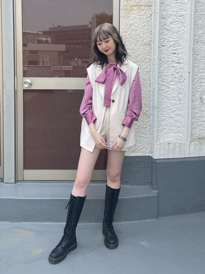 ピンク系のシャツ/ブラウス、ブラック系のブーツ、ホワイト系のベストを着用したレディースの春コーディネートの2枚目の写真