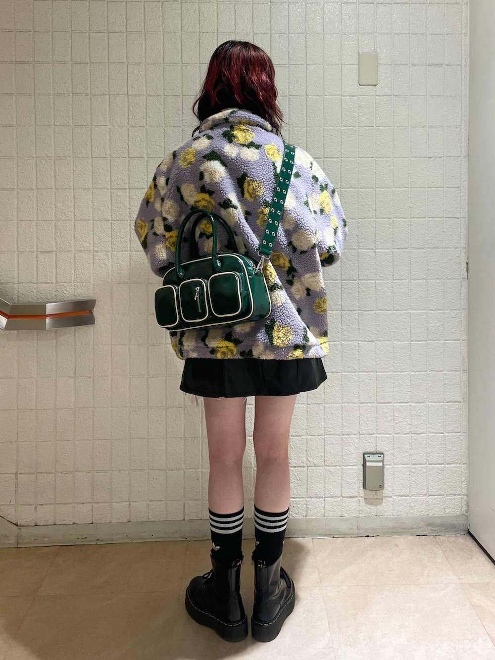 パープル系のブルゾン、ホワイト系のニット/セーター、ブラック系のジャンパースカートを着用したレディースの秋コーディネートの5枚目の写真