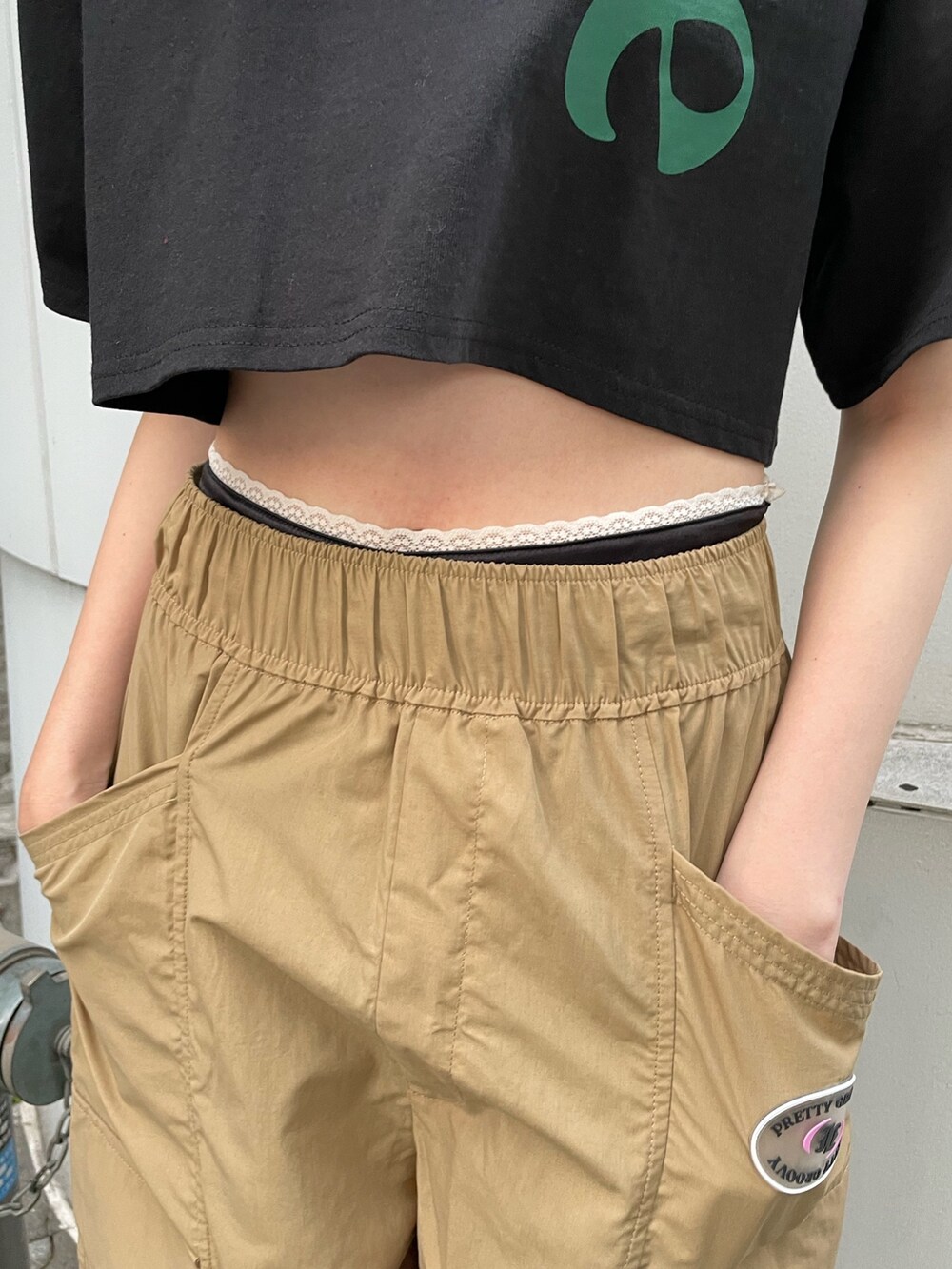 ベージュ系のカーゴパンツ、ブラック系のTシャツ/カットソー、ブラック系のブーツを着用したレディースの夏コーディネートの9枚目の写真