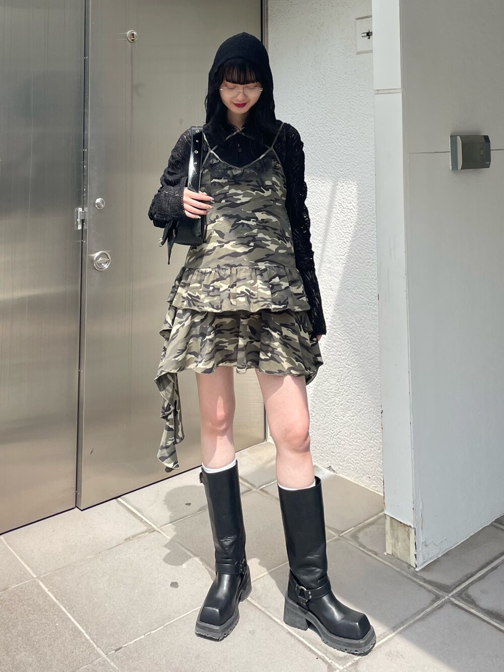ベージュ系のワンピース、ブラック系のブーツ、ブラック系のTシャツ/カットソーを着用したレディースの春コーディネートの2枚目の写真