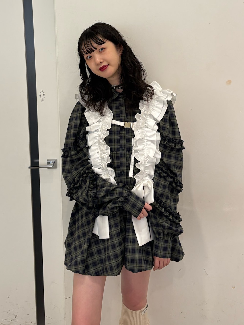 グリーン系のワンピース、ブラック系のスニーカー、ホワイト系のベルトを着用したレディースの夏コーディネートの4枚目の写真