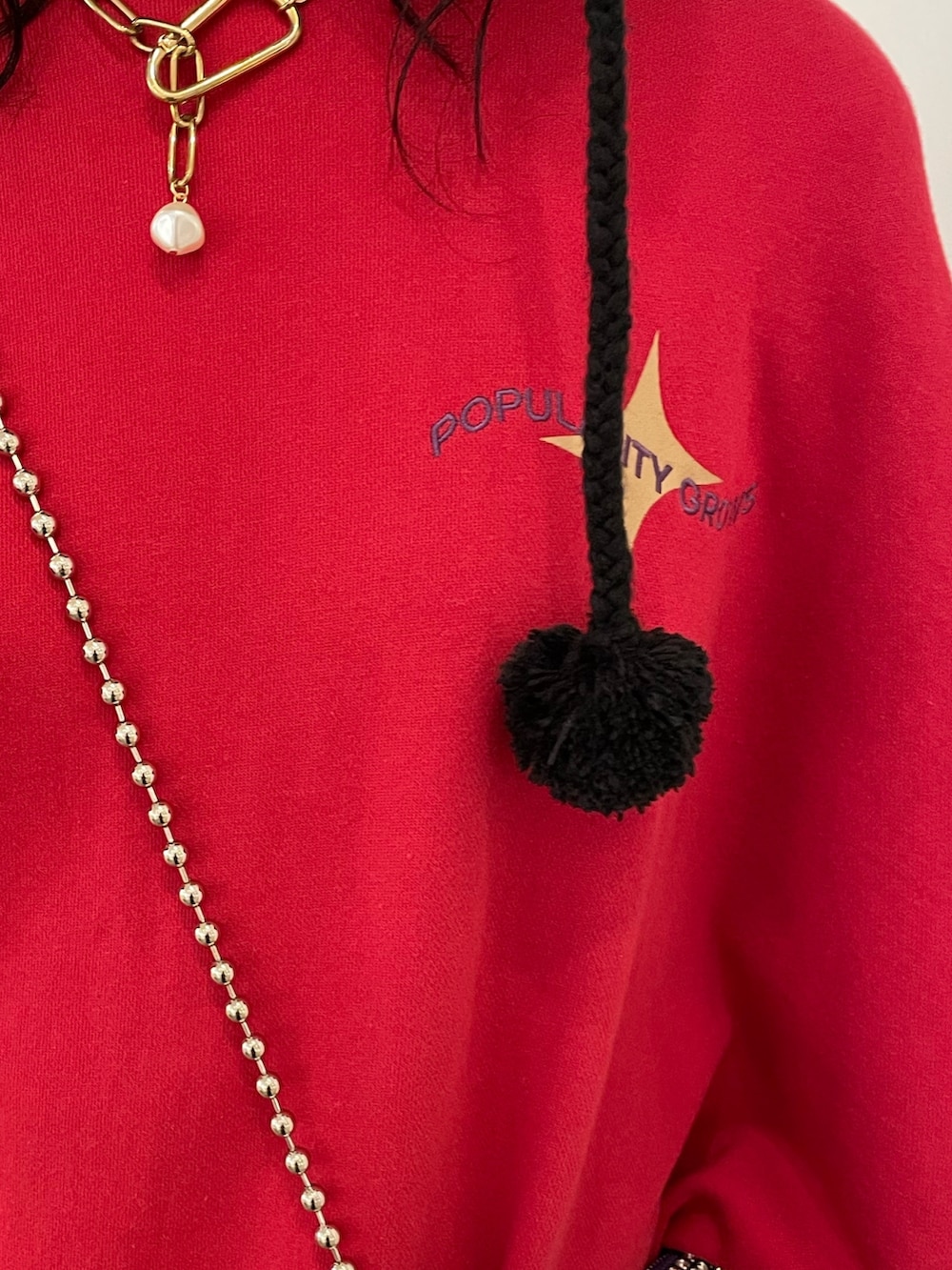 ブラック系のスカート、ブラック系のブーツ、レッド系のTシャツ/カットソーを着用したレディースの秋コーディネートの5枚目の写真