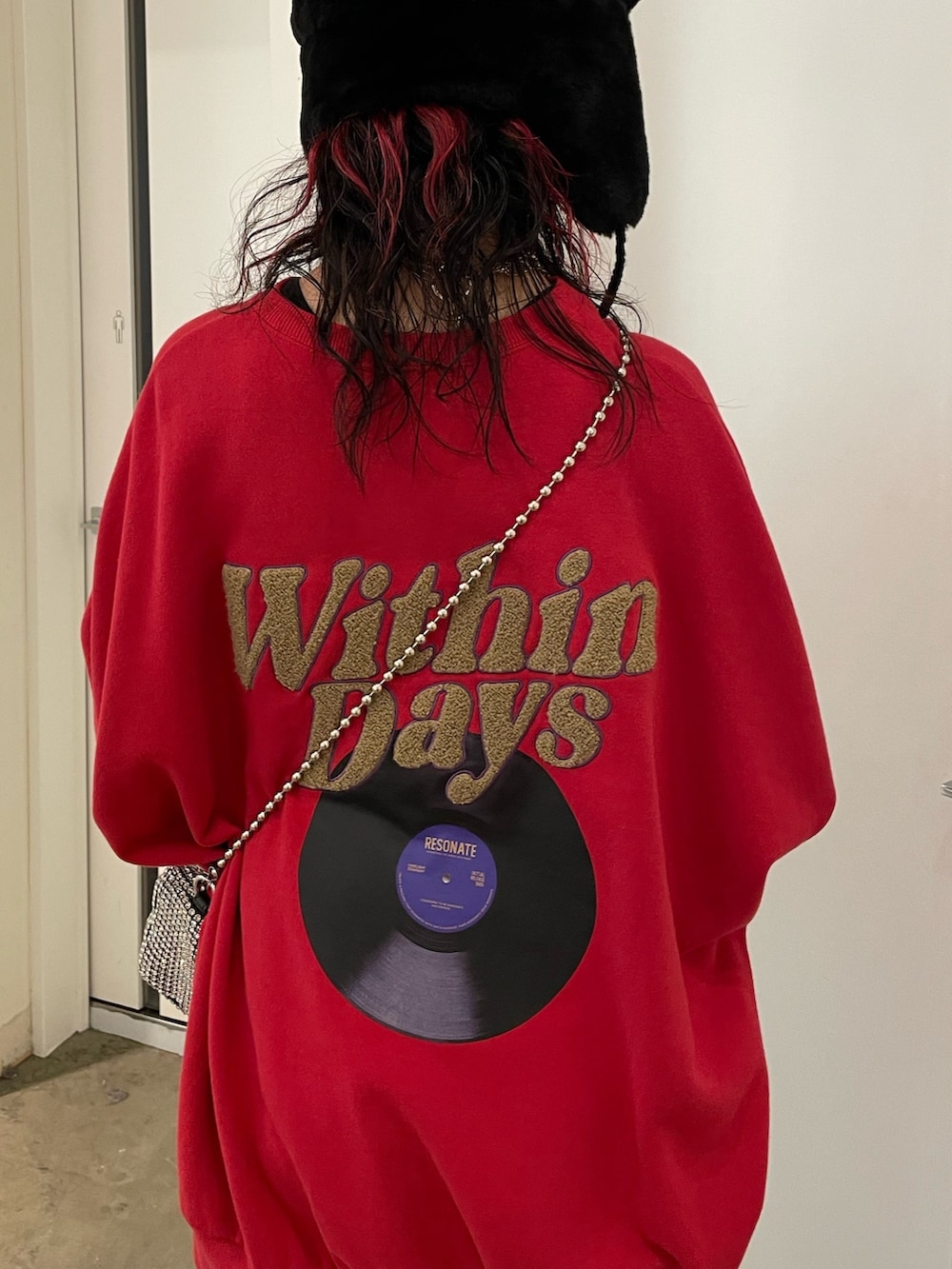 ブラック系のスカート、ブラック系のブーツ、レッド系のTシャツ/カットソーを着用したレディースの秋コーディネートの6枚目の写真