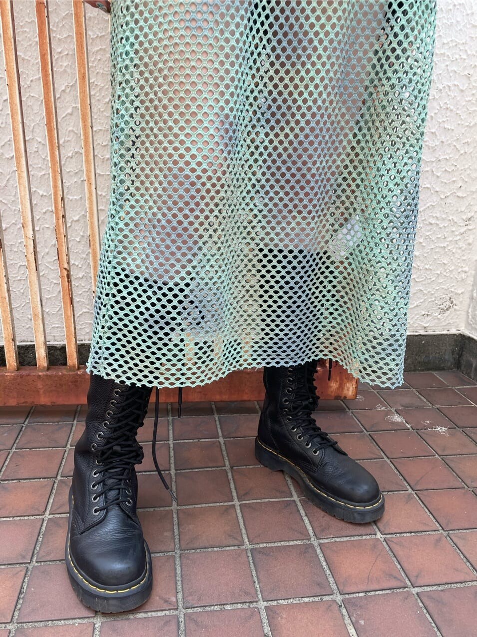 ブラック系のブーツ、ブラック系のTシャツ/カットソー、グリーン系のワンピースを着用したレディースの夏コーディネートの6枚目の写真