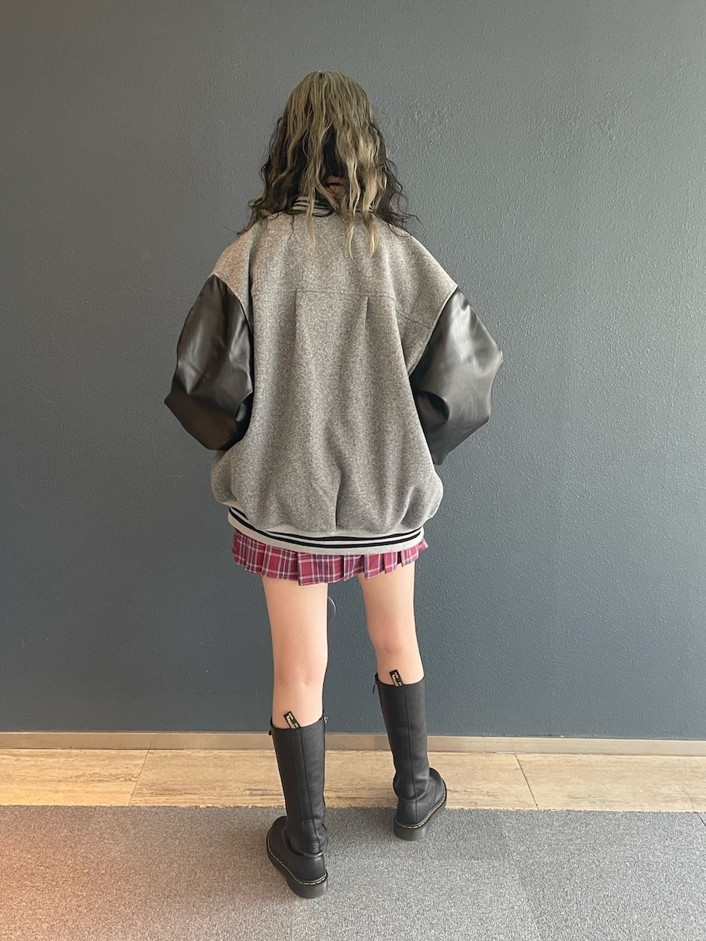 ピンク系のスカート、グレー系のスタジャン、ホワイト系のTシャツ/カットソーを着用したレディースの秋コーディネートの3枚目の写真