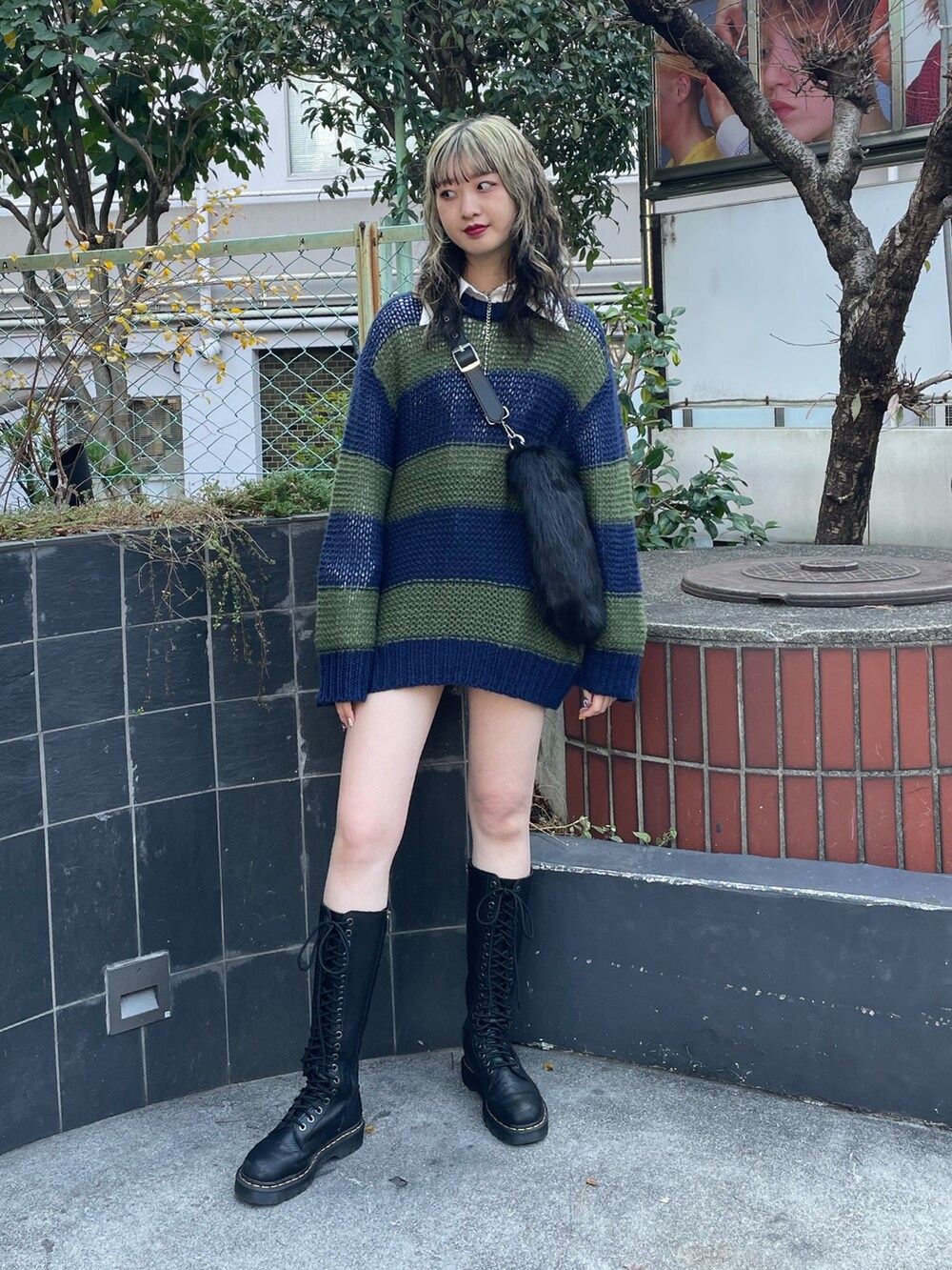 ブラック系のショルダーバッグ、ブラック系のブーツ、ブルー系のニット/セーターを着用したレディースの冬コーディネートの2枚目の写真
