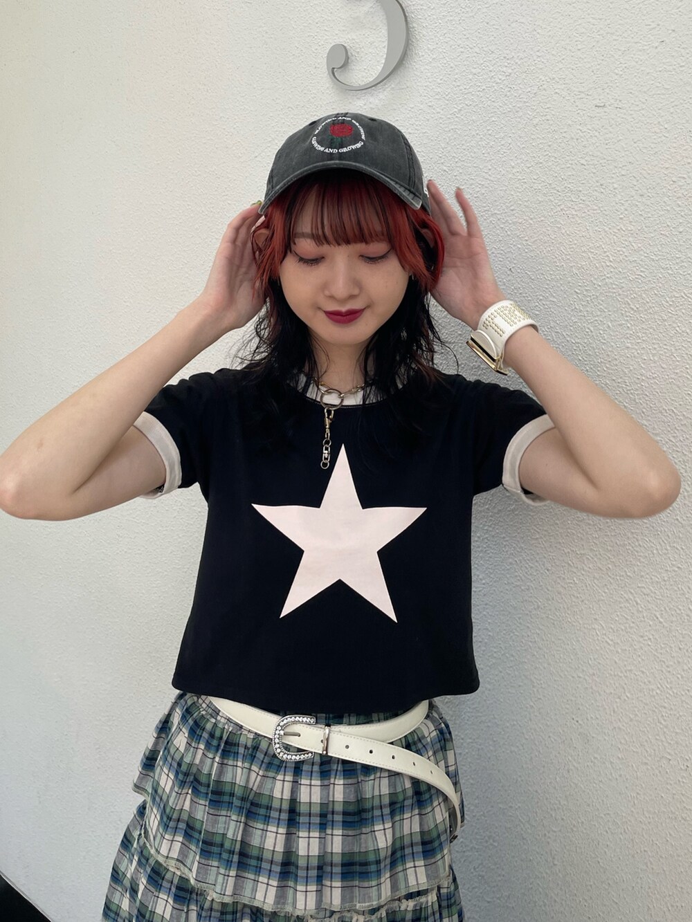 グリーン系のスカート、ブラック系のTシャツ/カットソー、ホワイト系のサンダルを着用したレディースの夏コーディネートの4枚目の写真