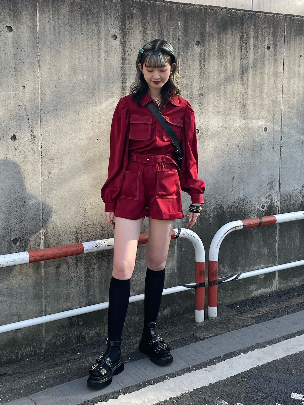 ブラック系のサンダル、レッド系のつなぎ/オールインワン、ブラック系のショルダーバッグを着用したレディースの春コーディネートの2枚目の写真
