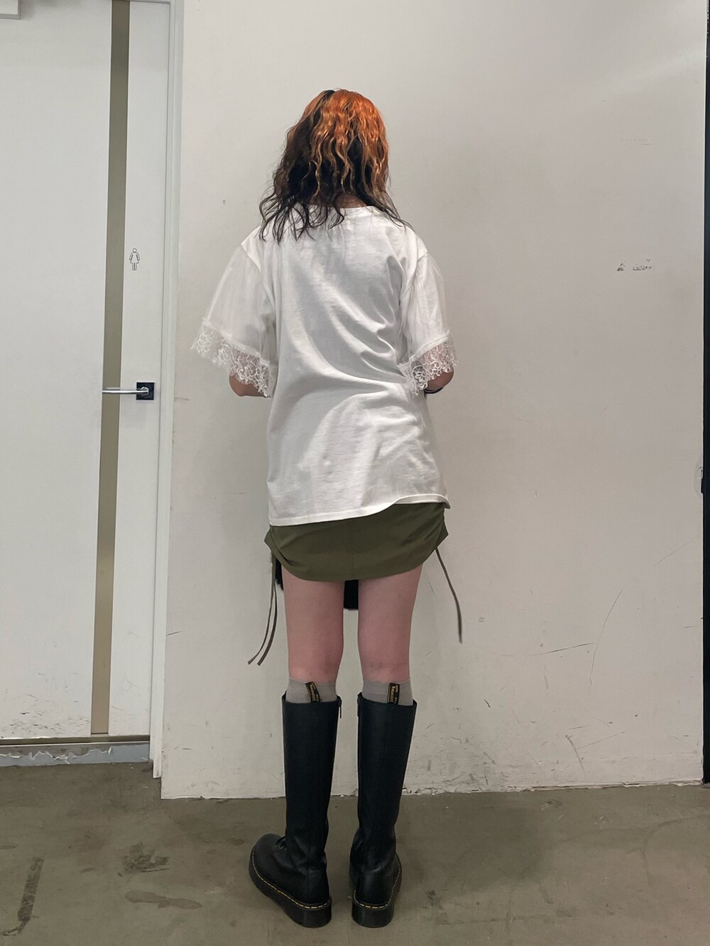 ホワイト系のTシャツ/カットソー、ブラック系のハンドバッグ、ブラック系のブーツを着用したレディースの夏コーディネートの3枚目の写真