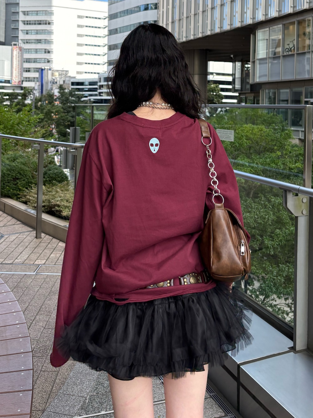 レッド系のTシャツ/カットソー、ブラック系のスカート、ブラック系のブーツを着用したレディースの夏コーディネートの4枚目の写真