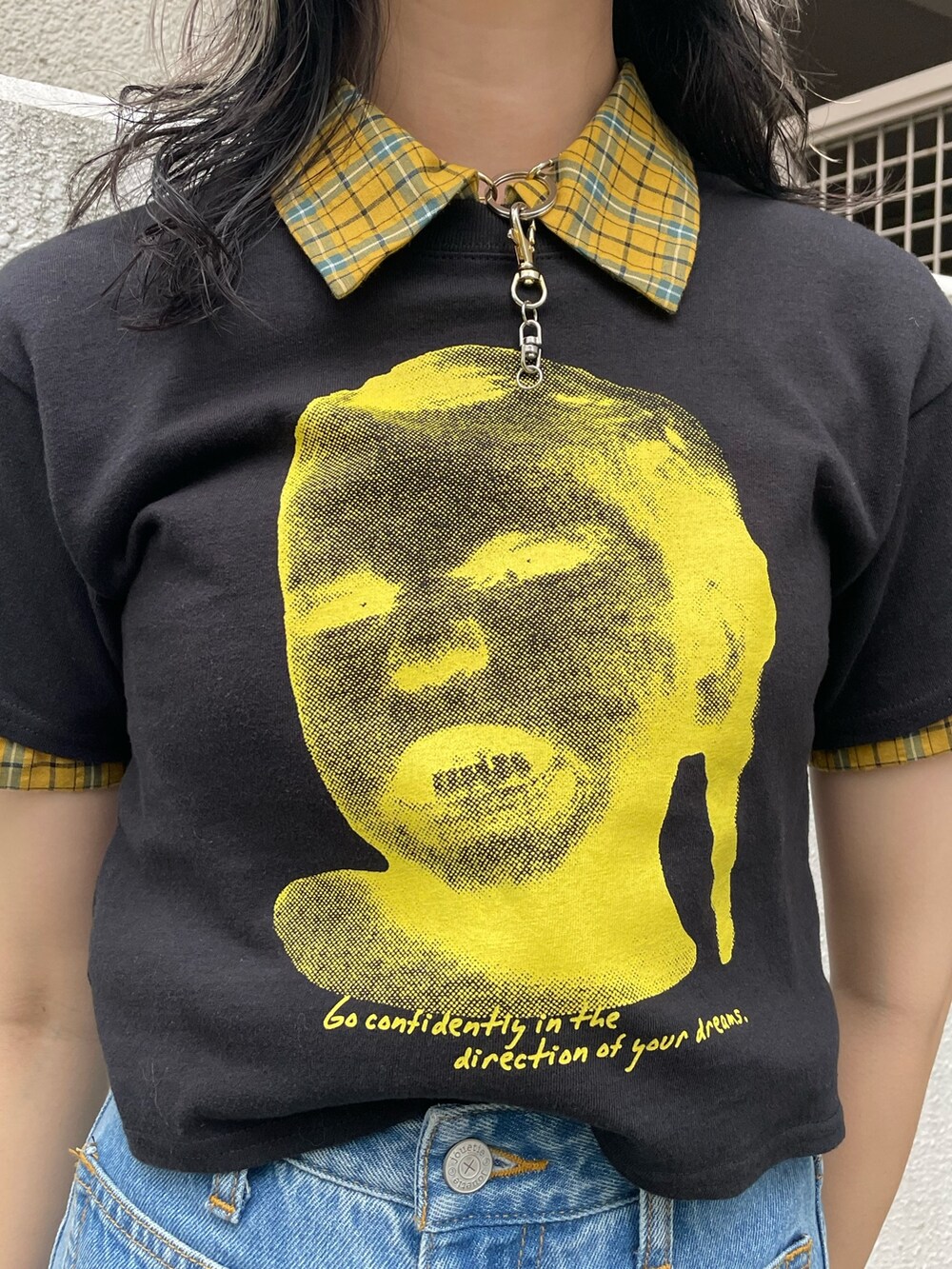 イエロー系のシャツ/ブラウス、ブラック系のTシャツ/カットソー、ブルー系のデニムパンツを着用したレディースの春コーディネートの6枚目の写真