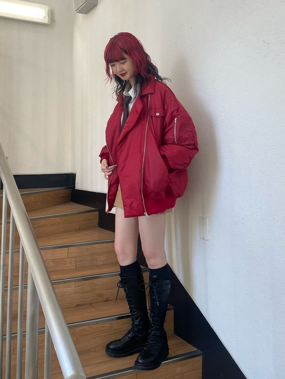 レッド系のMA-1、ホワイト系のシャツ/ブラウス、レッド系のネクタイを着用したレディースの秋コーディネートの2枚目の写真