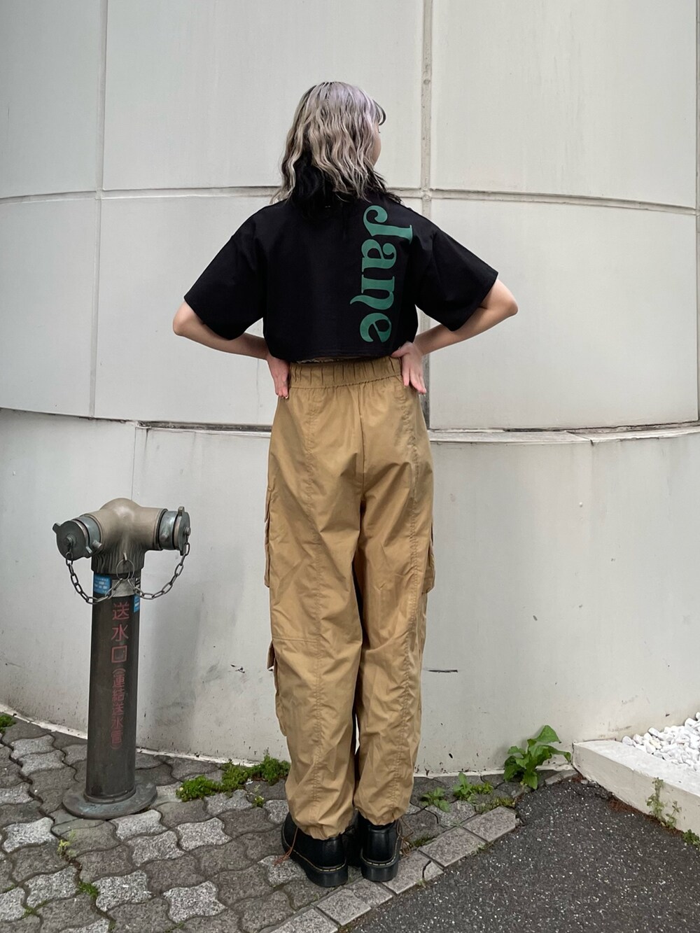 ベージュ系のカーゴパンツ、ブラック系のTシャツ/カットソー、ブラック系のブーツを着用したレディースの夏コーディネートの3枚目の写真