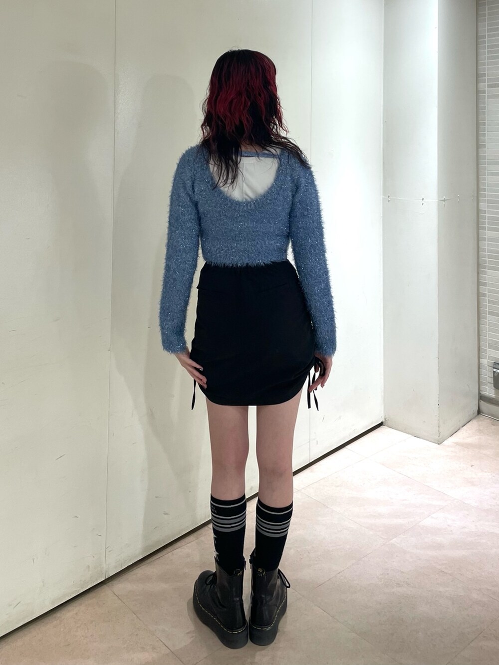 ブルー系のニット/セーター、ホワイト系のタンクトップ、ブラック系のスカートを着用したレディースの冬コーディネートの3枚目の写真