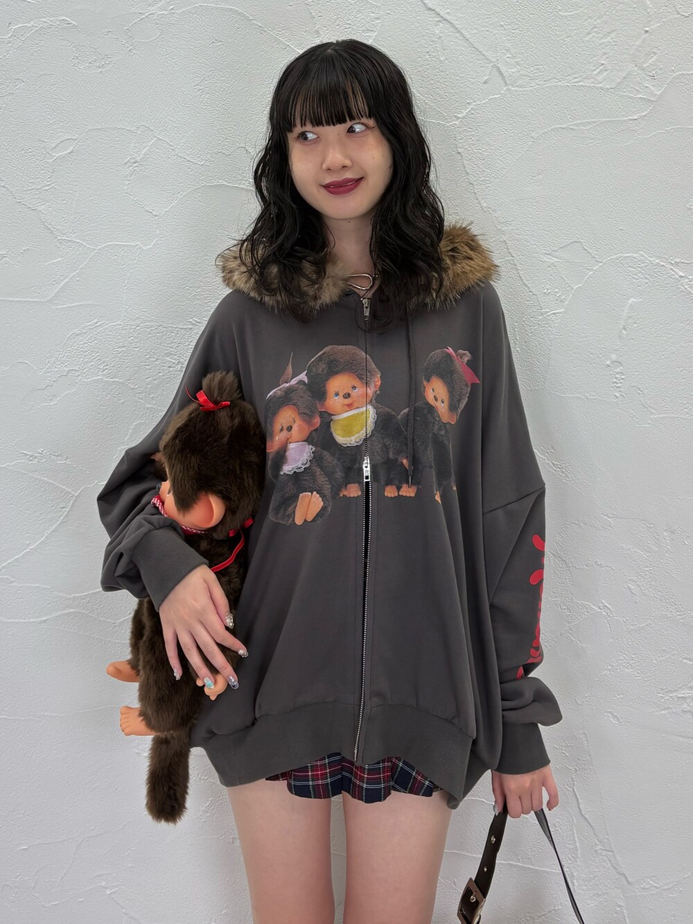 ブラック系のパーカー、ブルー系のスカート、ブラック系のショルダーバッグを着用したレディースの夏コーディネートの4枚目の写真