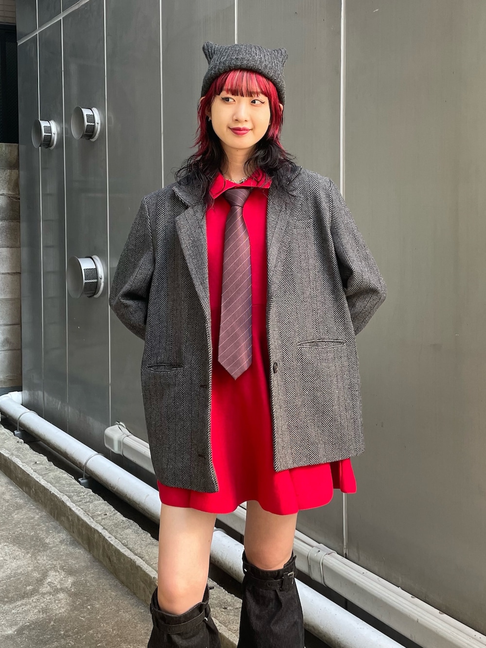 グレー系のテーラードジャケット、レッド系のネクタイ、レッド系のワンピースを着用したレディースの夏コーディネートの4枚目の写真