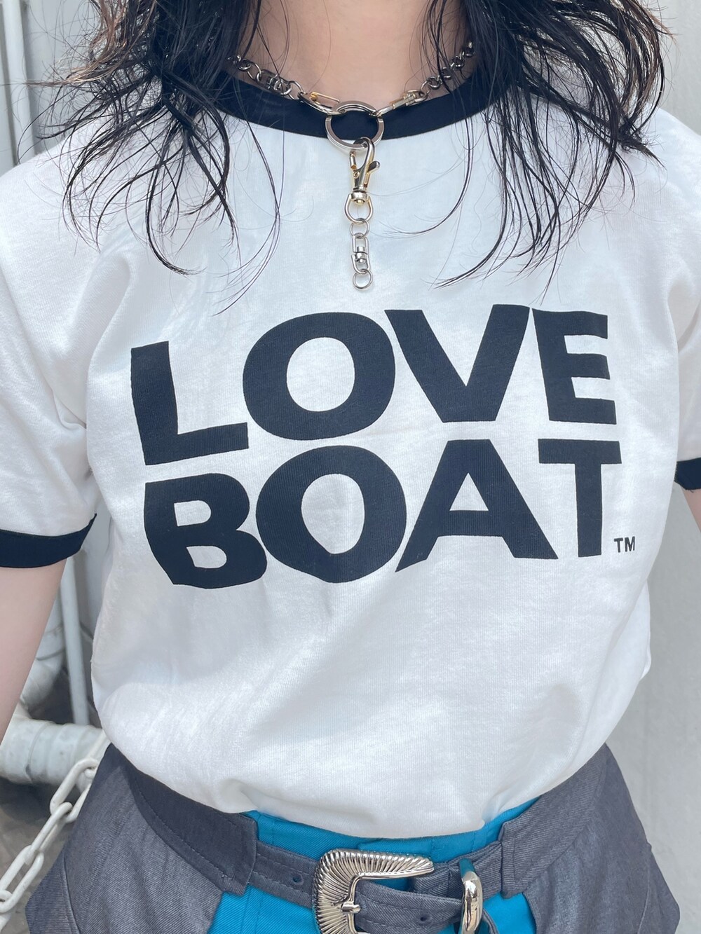 ホワイト系のTシャツ/カットソー、ブルー系のスカート、ブラック系のハンドバッグを着用したレディースの春コーディネートの4枚目の写真