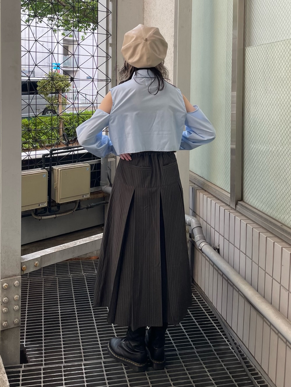 グレー系のスカート、ブルー系のシャツ/ブラウス、ブラック系のブーツを着用したレディースの春コーディネートの3枚目の写真