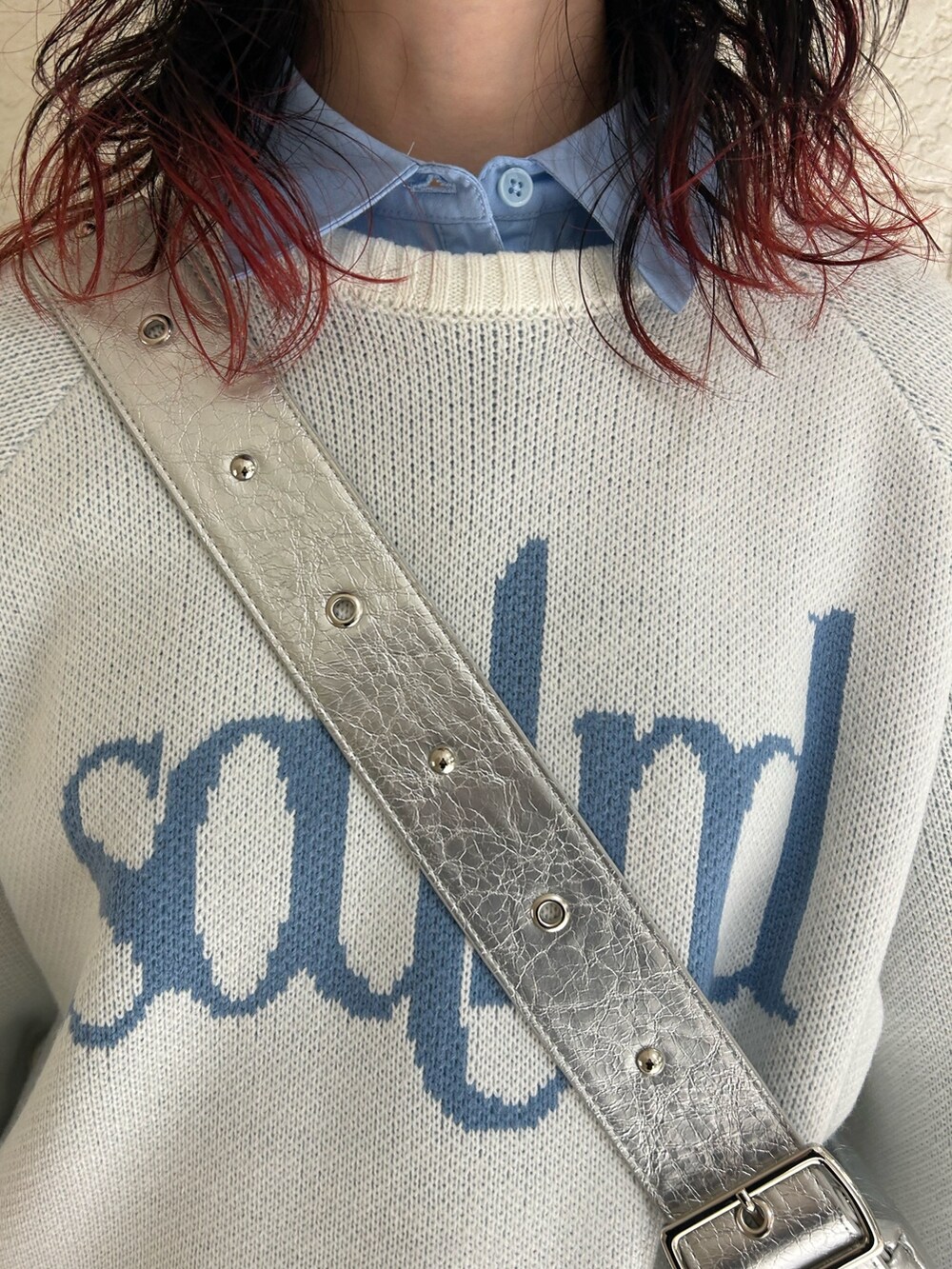 ホワイト系のニット/セーター、ブルー系のシャツ/ブラウス、シルバー系のショルダーバッグを着用したレディースの冬コーディネートの4枚目の写真