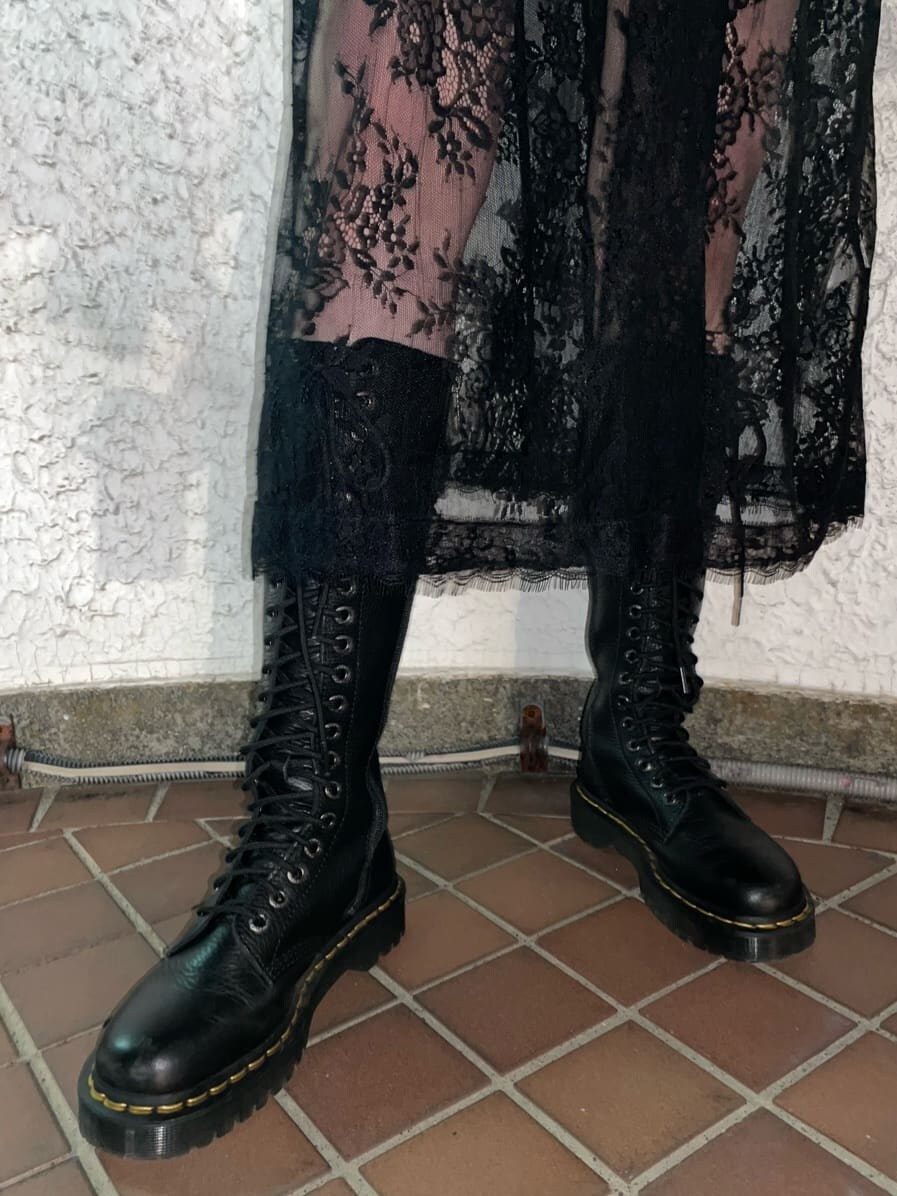 ブラック系のブーツ、ブラック系のデニムパンツ、ブラック系のワンピースを着用したレディースの春コーディネートの8枚目の写真