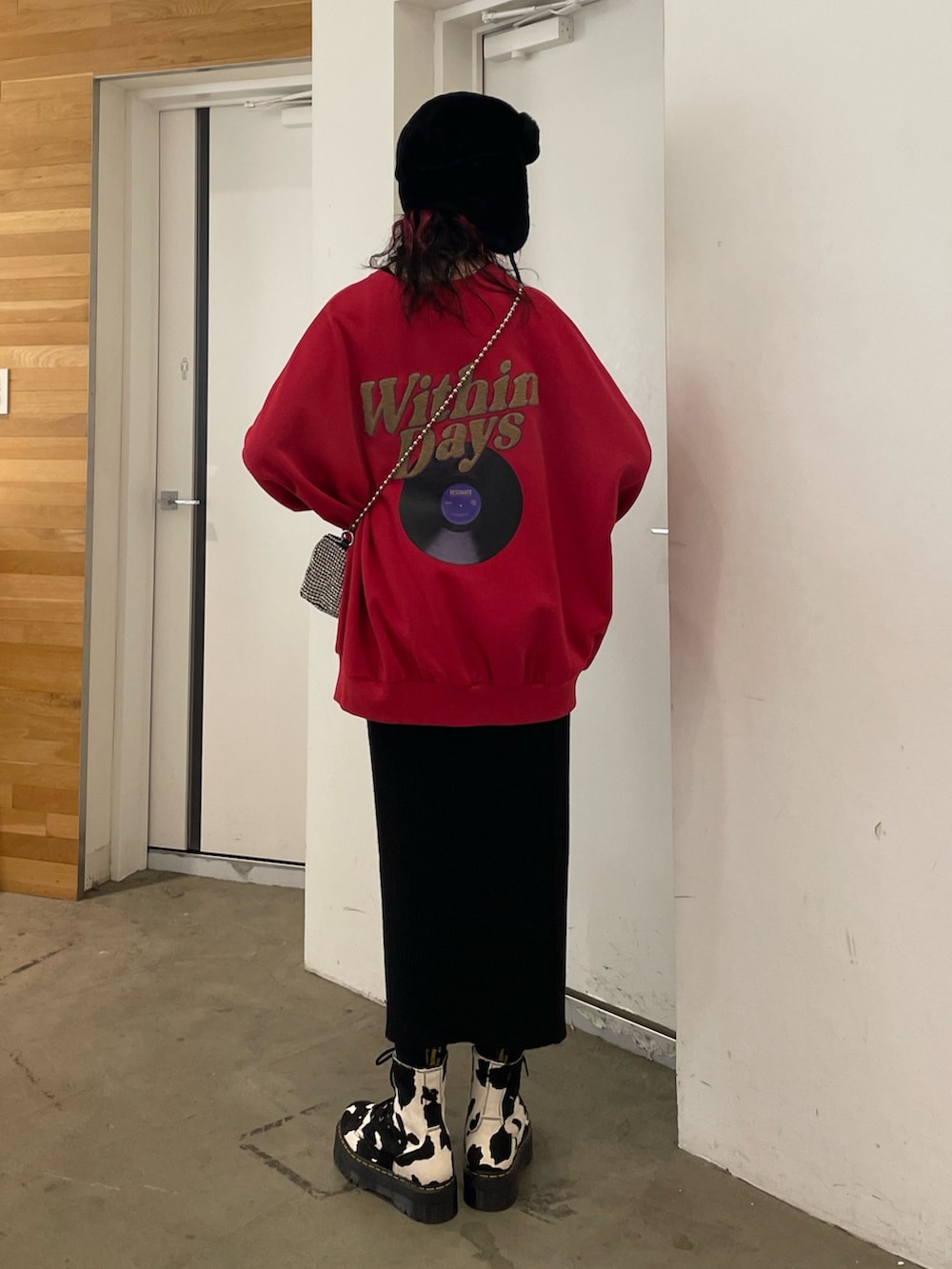 ブラック系のスカート、ブラック系のブーツ、レッド系のTシャツ/カットソーを着用したレディースの秋コーディネートの3枚目の写真